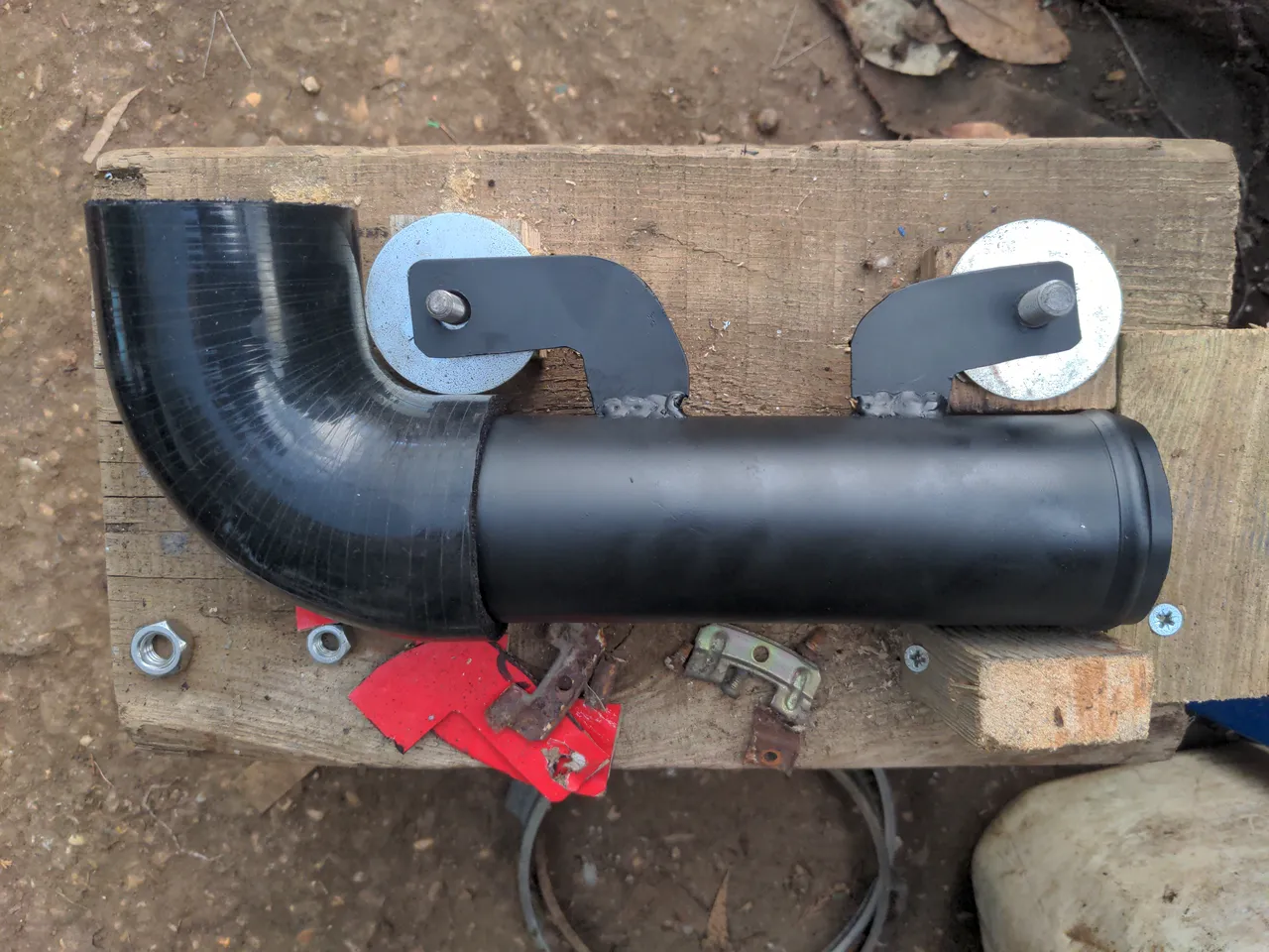 The completed steel intake pipe. Instead of a 90 degree bend in the pipe itself, it now has a 90 degree silicone hose fitted. The steel part is painted black.