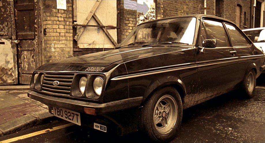 A Mark II Ford RS2000, as shown in Lock Stock and Two Smoking Barrels. It is black, a little grimy, and there is a sepia tone to this movie still.