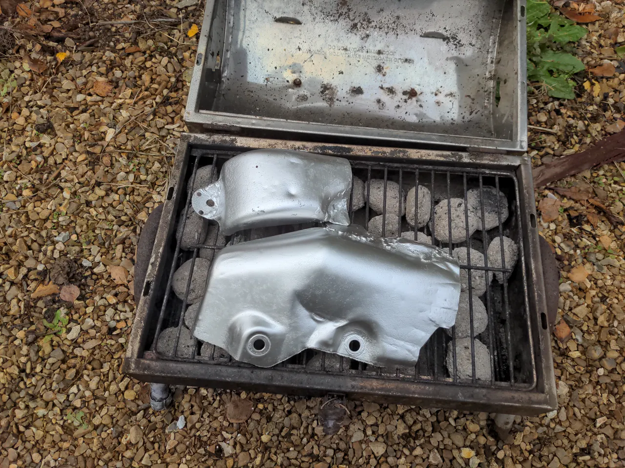 Both sections of my heat shield are painted silver, and are sitting in my BBQ, with the charcoal now fully grey.