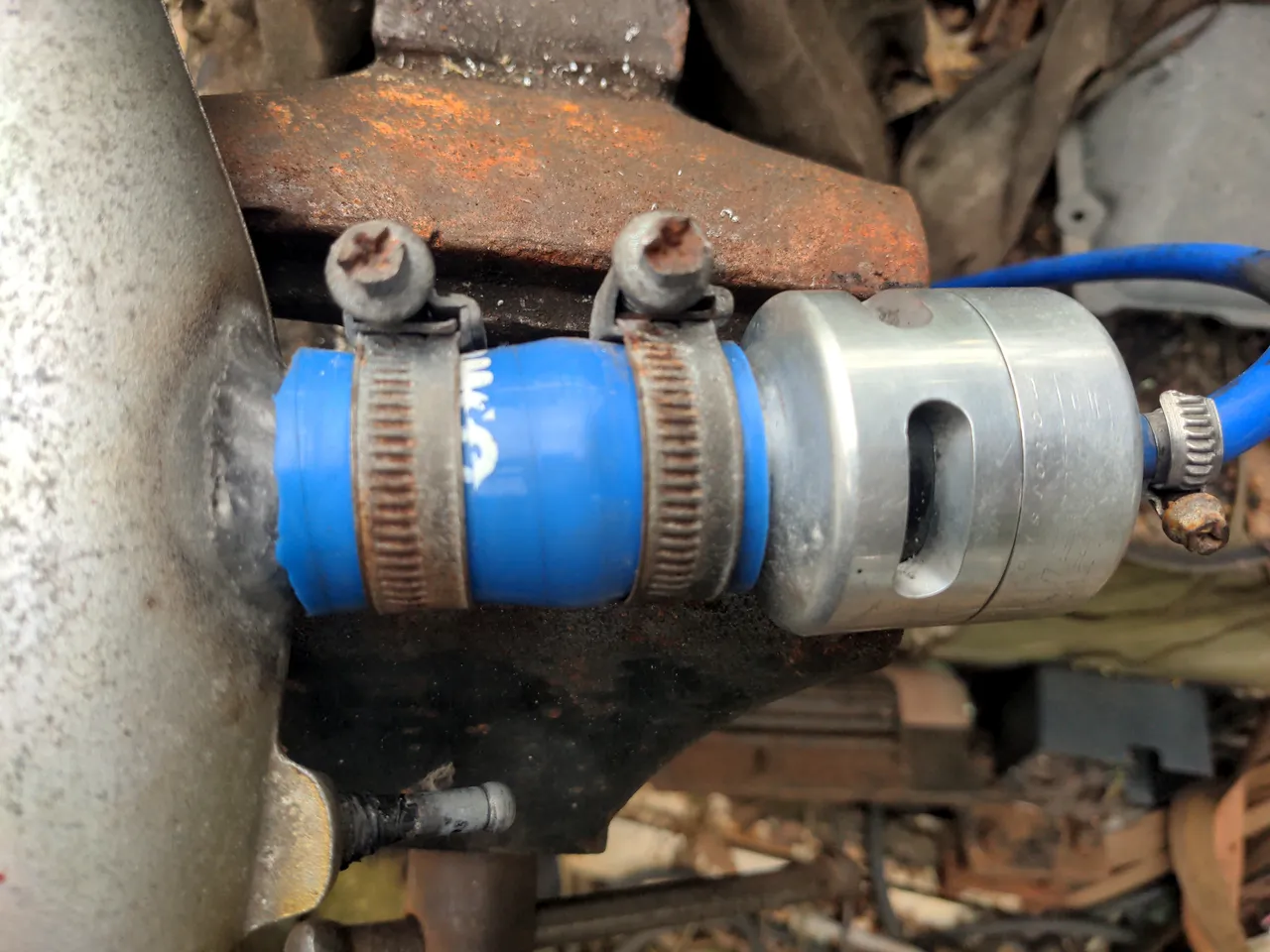 A silver Bailey DV26 attached to my pipe via a blue Samco coupling hose.