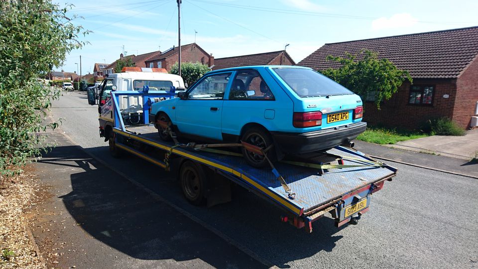 Mazda 323 GTX loaded onto a recovery truck