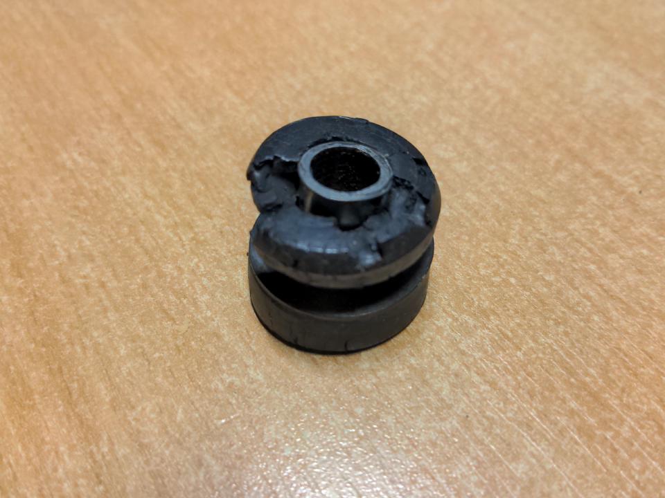 A cracked mounting rubber with several pieces missing from it.