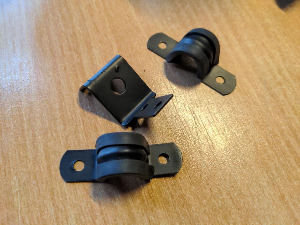 Two pipe clamps, and the boost controller bracket from earlier, now painted in satin black Jenolite paint.