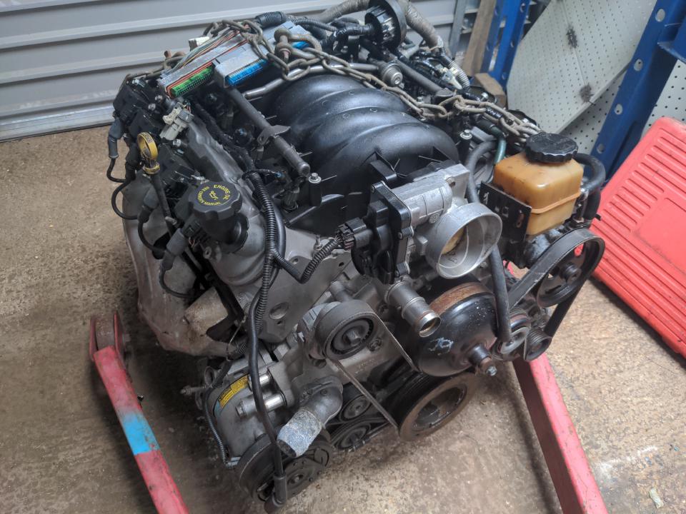 A Chevrolet LS engine. It is a compact V8 engine. It sits on a concrete floor