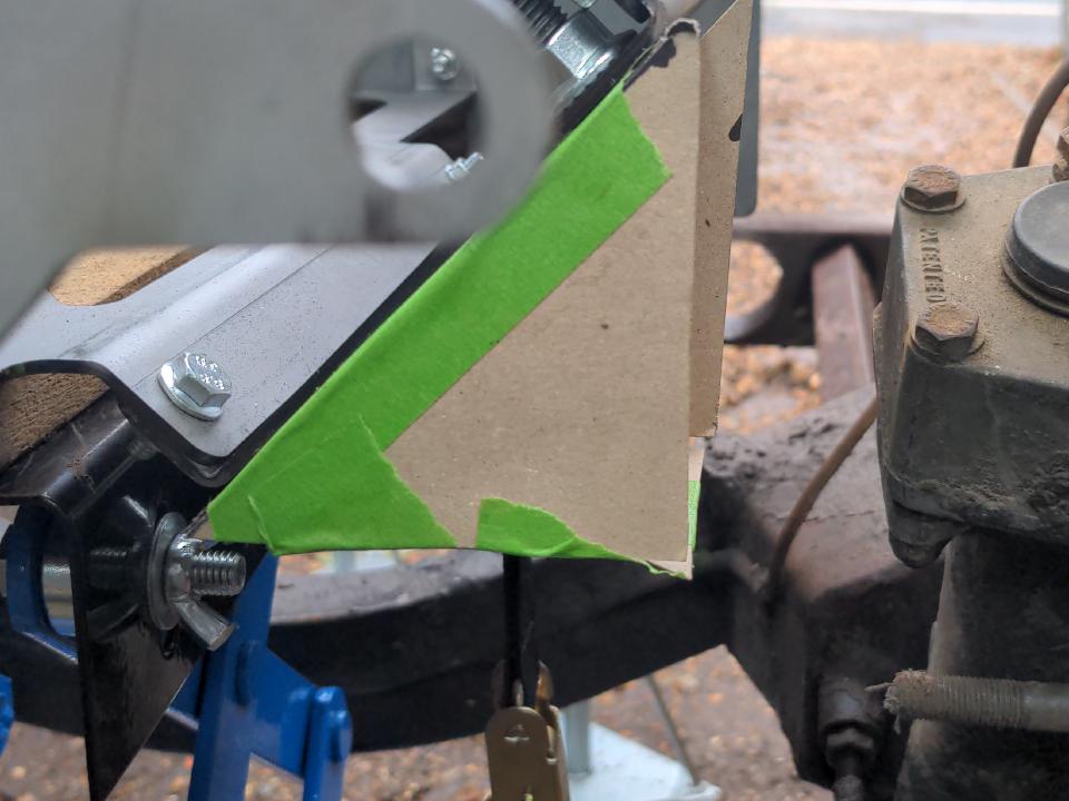 A triangular-shaped-box cardboard mockup of an engine mount mount, with an obvious flaw.