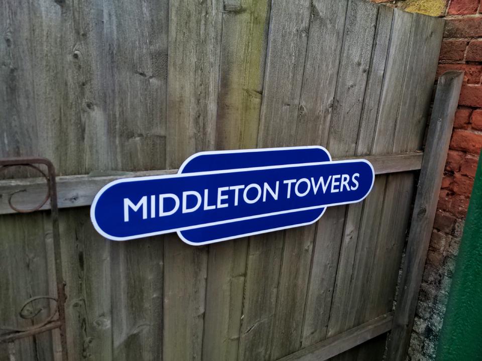 The reproduction sign for Middleton Towers in situ at the station, mounted to the fence via my bracket (which is hidden behind the sign).