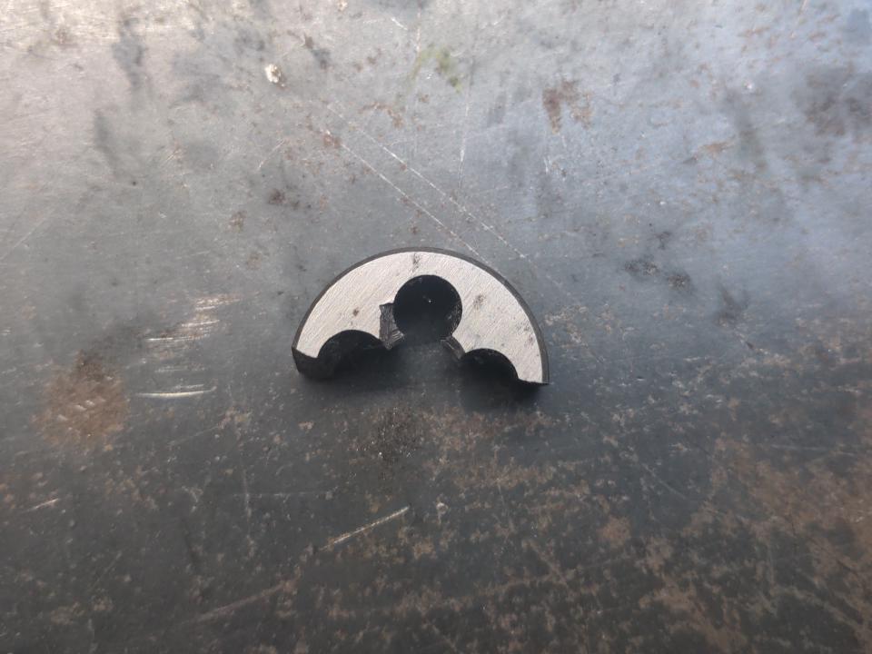 A broken die (a tool for cutting threads onto rods).