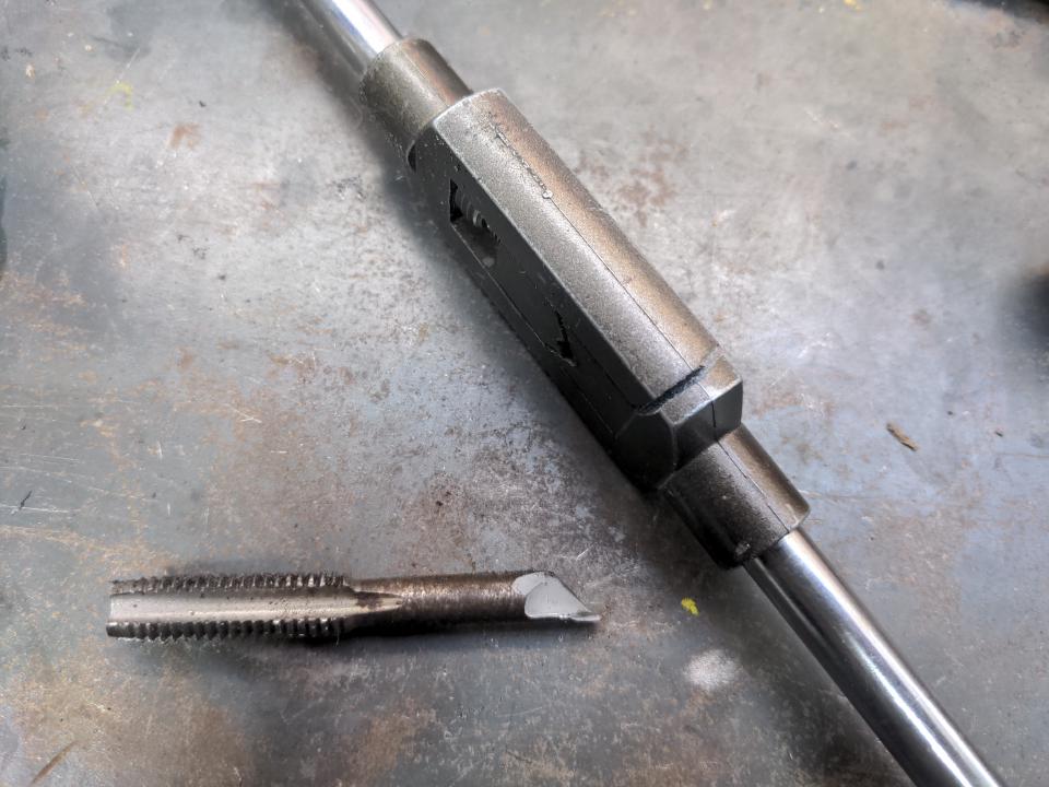 A broken tap (a tool for cutting threads into holes) and a broken handle (which attaches to the tap to turn it).