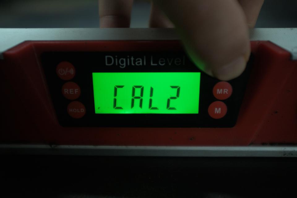 My digital level reading CAL2 on its backlit green LCD display, indicating a second calibration measurement has been read.