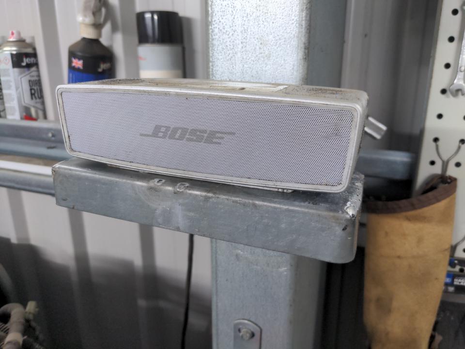 A dry run of the speaker shelf. The speaker sits on top of it. It is magnetically attached to the steel column (part of the workshop frame) in the background.