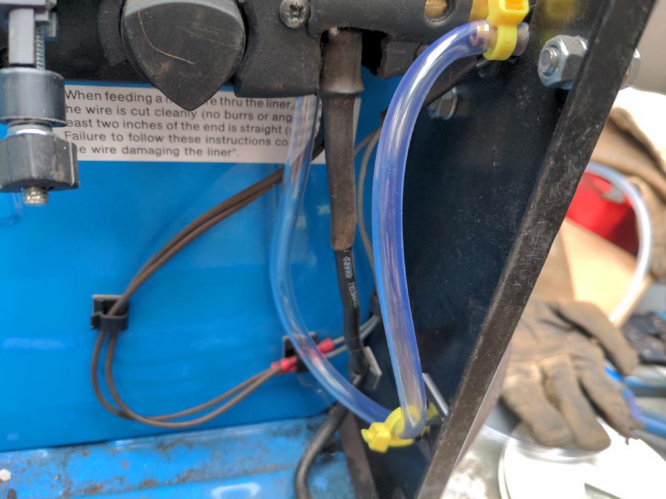 The gas feed entering into the non-spicy side of the welder, coming down in a loop, and then connecting to the gas feed port on the Euro torch socket.