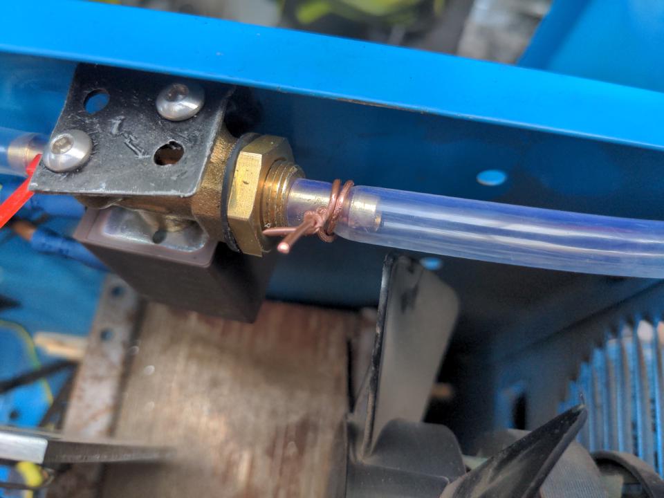 An improvised hose clip made from twisting a piece of single-core electrical wire.