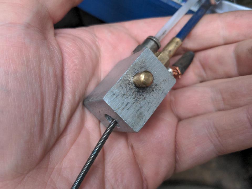 A gas valve from the inside of a welding torch. A small sticky-outy bit is the actuator for the valve; when this is pressed, gas flows.