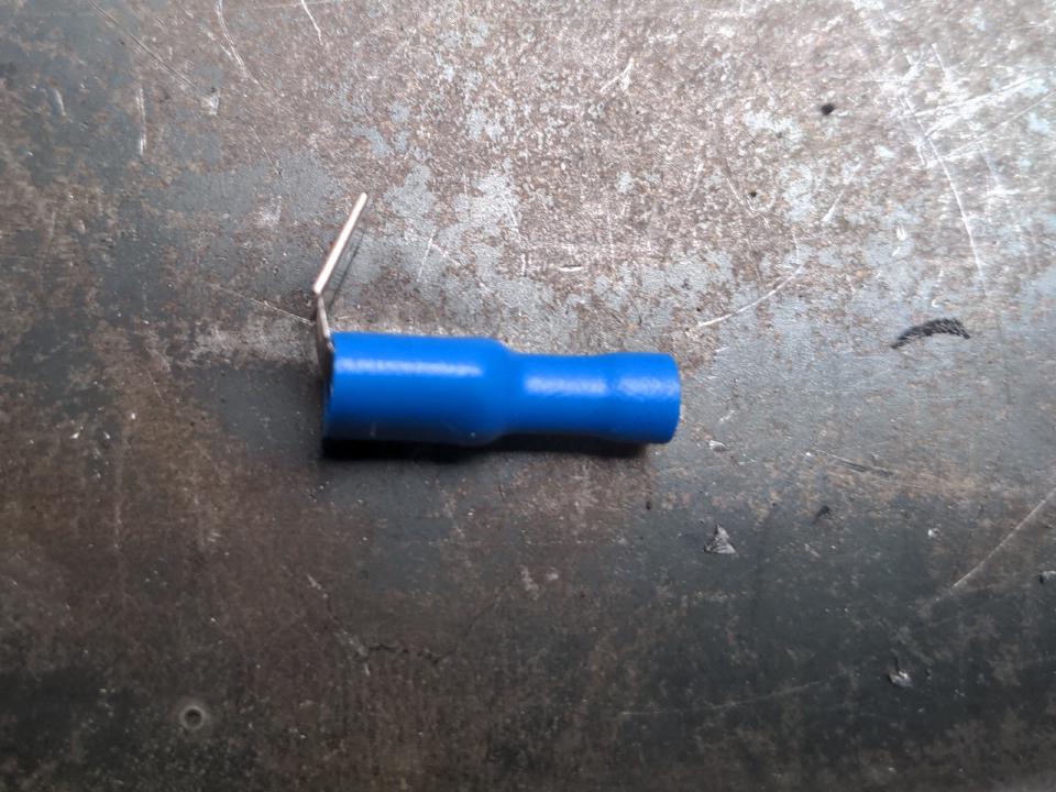 A piggyback spade connector. It looks like a normal electrical spade connector, but it has an extra prong coming out to allow attaching another spade connector.