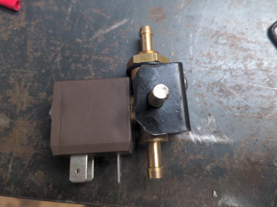A small bracket made out of thin angle iron with the solenoid attached to it.