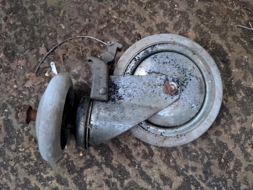 A swivelling castor wheel, not dissimilar to one you would find on the rear of a shopping trolley, but rather more heavy-duty. The wheel is about 6 inches in diameter.