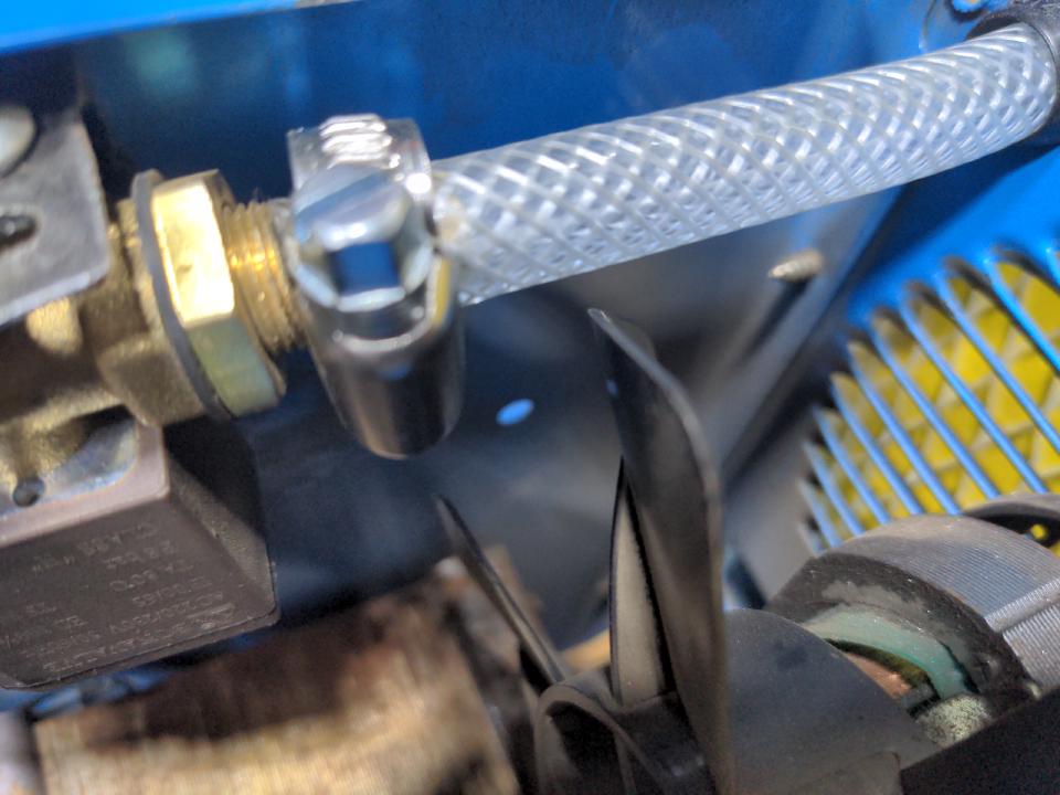 A slightly blurry picture of the new hose in the internals of my welder, which is much thicker than the tubing in the previous photo, and now held on to the solenoid with a proper Jubilee clip. There is about half a centimeter of clearance between the gas hose and the cooling fan.