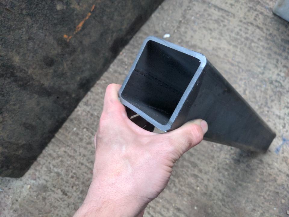 A piece of box section steel in my hand. It is a long extruded box; it measures 80x80mm on the outside and has a wall 5mm think. The piece is about 60 centimeters long.