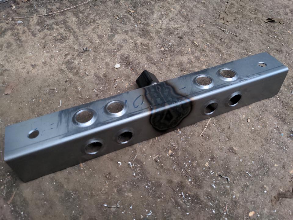The same piece of steel angle section, but with eight 3/4" holes drilled in which have been turned into dimples with a dimple die.