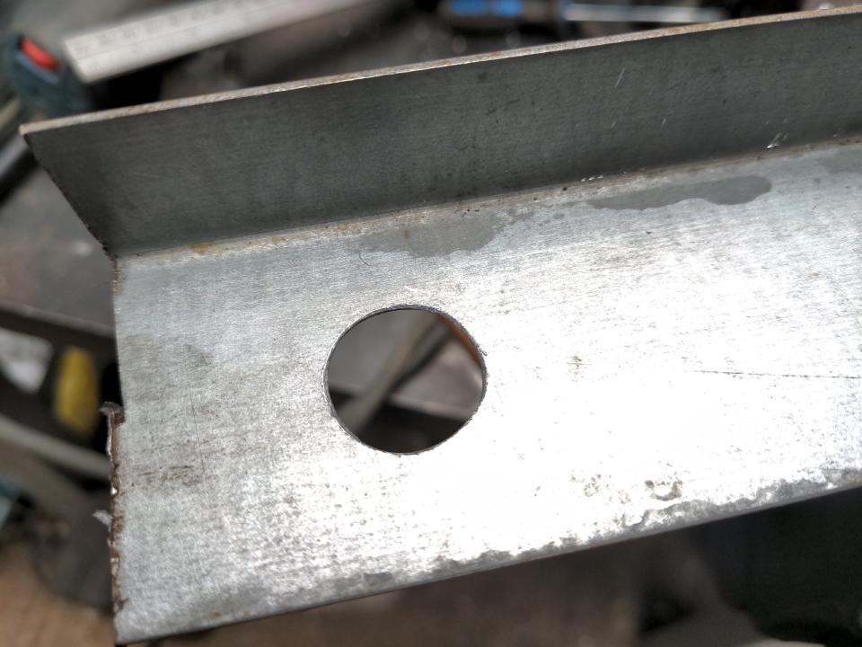 A piece of scrap 1mm steel with a hole drilled into it.
