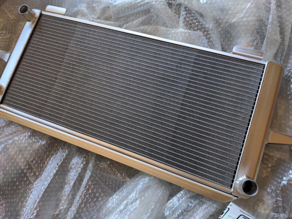 A car coolant (water) radiator measuring about 850x350mm. It is satin silver in colour.