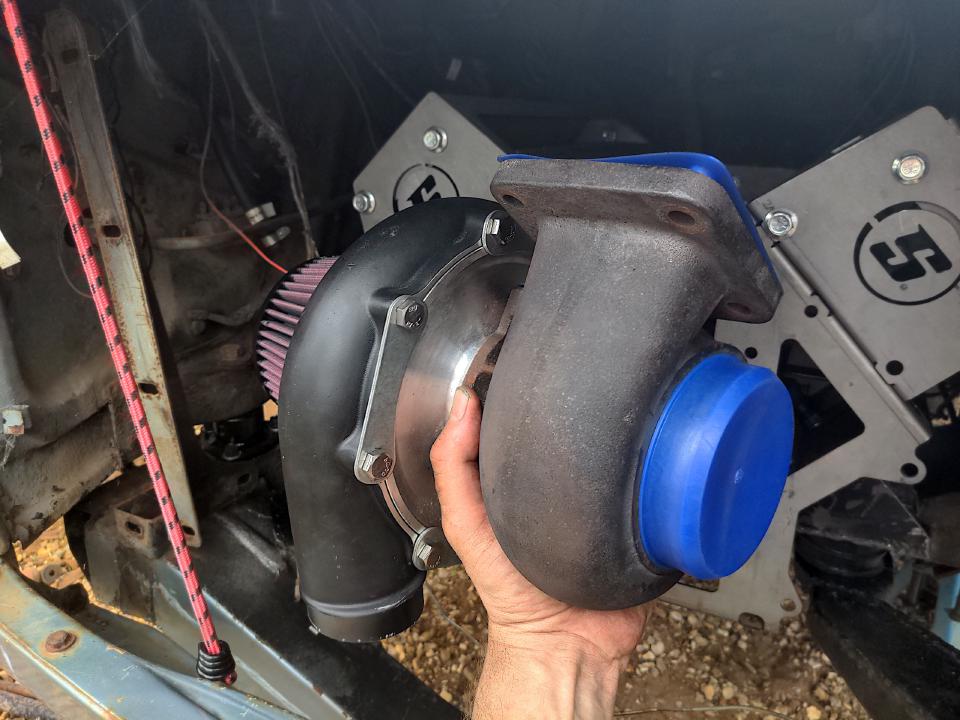 Me holding a massive turbo in the space where the radiator used to be in my Rover P5.