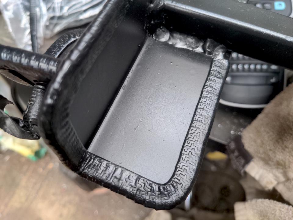 A close-up of the steel angle part of this subframe now edged with push-on edge protector. It is black and rubberish with internal steel reinforcement, and extends about 10mm inwards from the edge.