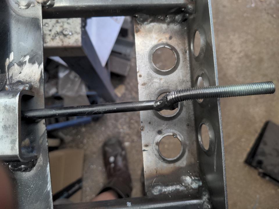 The lever operating a gas ram on a desk chair. The end has been cut off and a long M8 bolt has had the head cut off, the shank bent through 90 degrees, and was then welded on to the old lever to extend it.