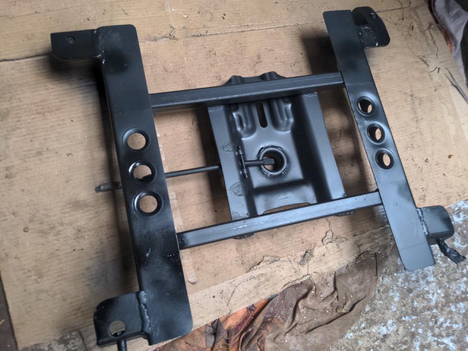 The same subframe, other side, with a coat of satin black paint (which is visibly not fully dry).
