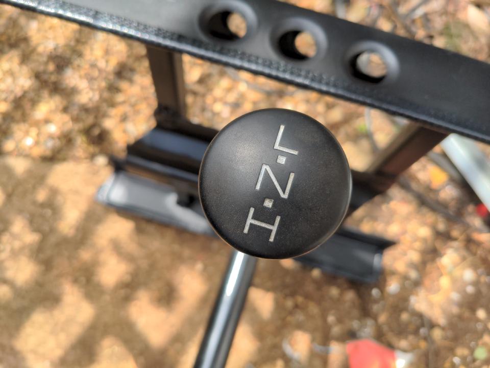 A black circular knob with "H - N - L" (high - neutral - low) engraved into it with large, thin white lettering.