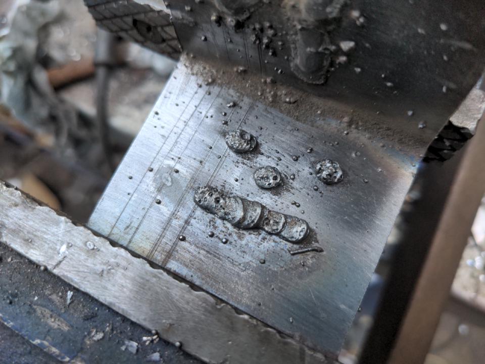 A face drawn onto some metal with my MIG welder, showing signs of porosity