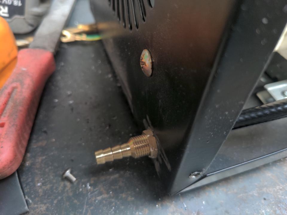A bulkhead fitting on the back of the welder; gas will pass through it. It is a neater solution than a hole and a grommet for passing it through a steel "wall".
