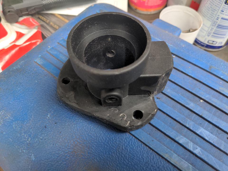 My modified Euro torch plug. On the left edge, the round has been cut flat and a piece of plastic has been "welded" in to replace it. On the bottom a notch has been added to accomodate a screw hole, and that has been tidied up with some random piece of plastic.
