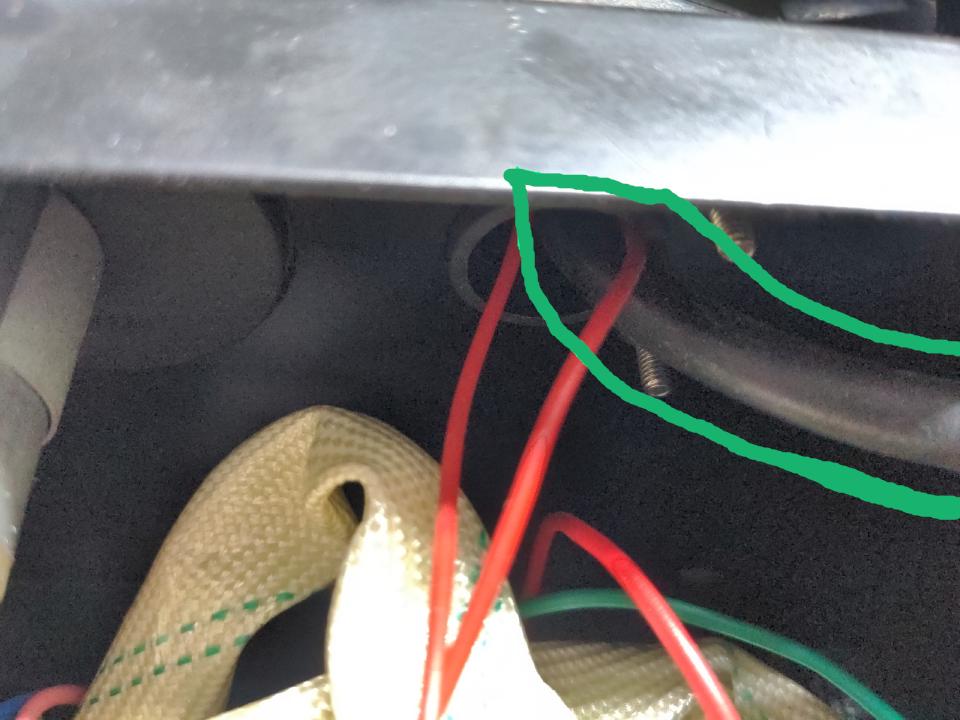 A view of some wires going into the top deck of the MIG welder; a thick black cable is outlined.