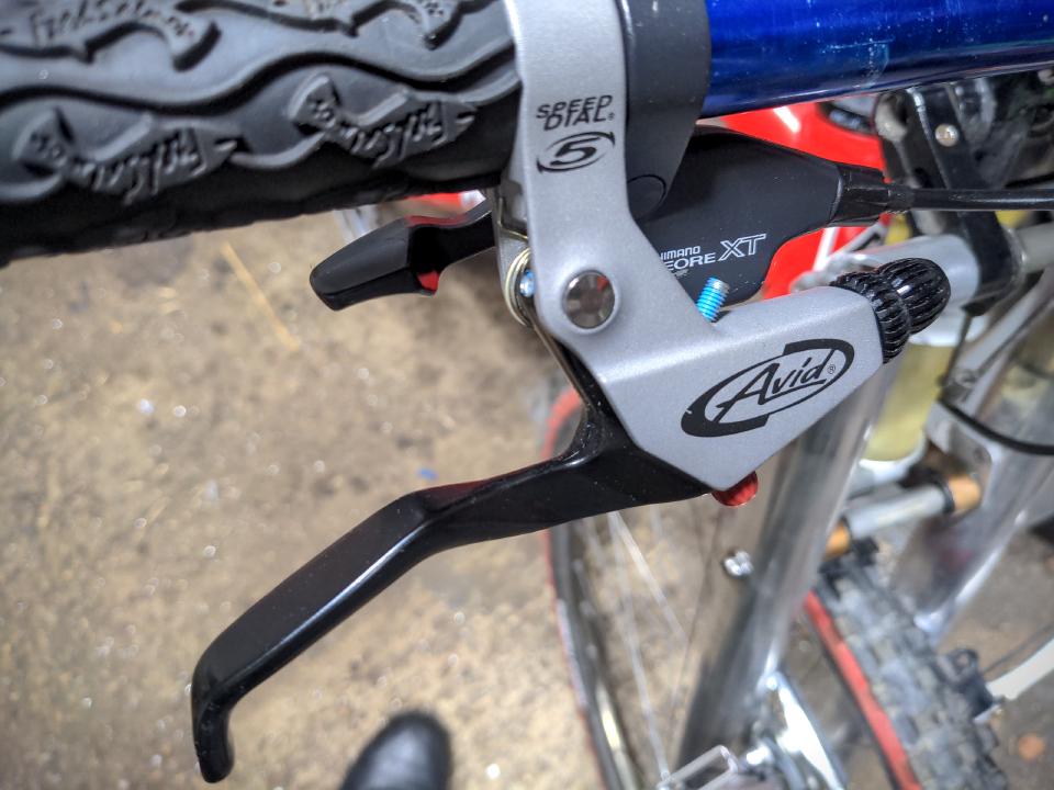 An Avid Speed Dial 5 brake lever. It has a large, angular lever, and the body is a light grey colour.