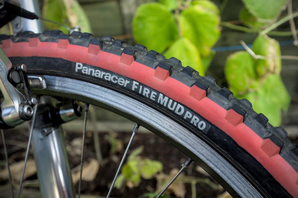 A close-up of the white writing on the sidewall of the Panaracer Fire Mud Pro tyres. These ones have a decorative red band along the circumference of the sidewall near the tread.