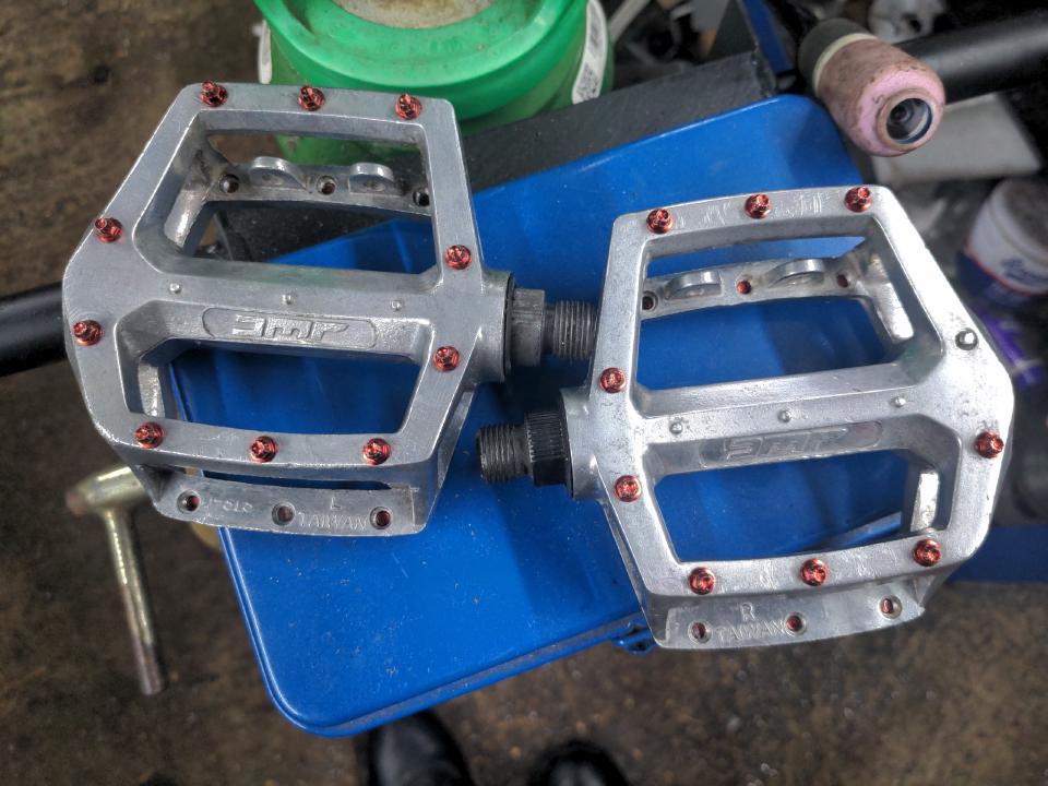 The pedals in the previous picture, but have been degreased, polished, and have 10 red anodised studs each side replacing the old ones (including the missing one), though one pedal has a stubborn stud which did not come out and has been left in place.