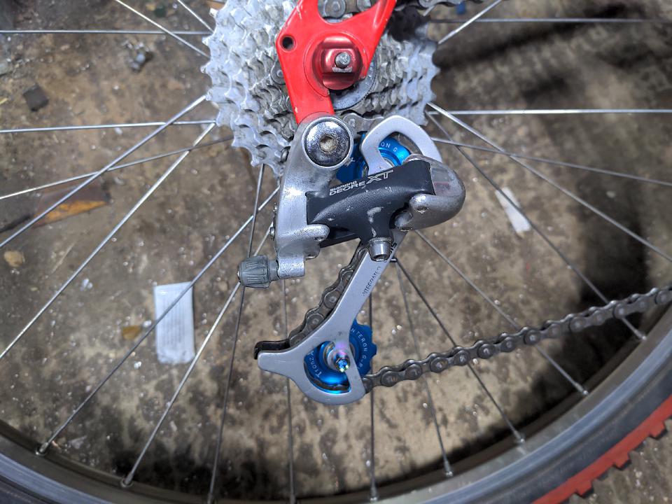 The rear mech cleaned and fitted with the blue jockey wheels and rainbow anodised bolts.