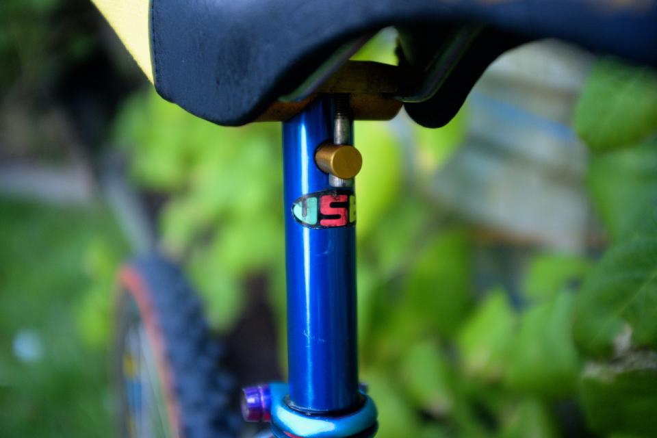 A close up of the USE sticker on a blue anodised USE seat post.