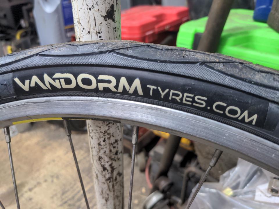 A close-up of the white "VANDORMTYRES.COM" label on some black Vandorm slick tyres.