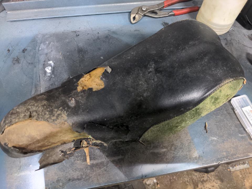 A Setlaz Downhill seat. It is in very sad condition; the leather cover is flaking off, and the Kevlar corners have gone mouldy.