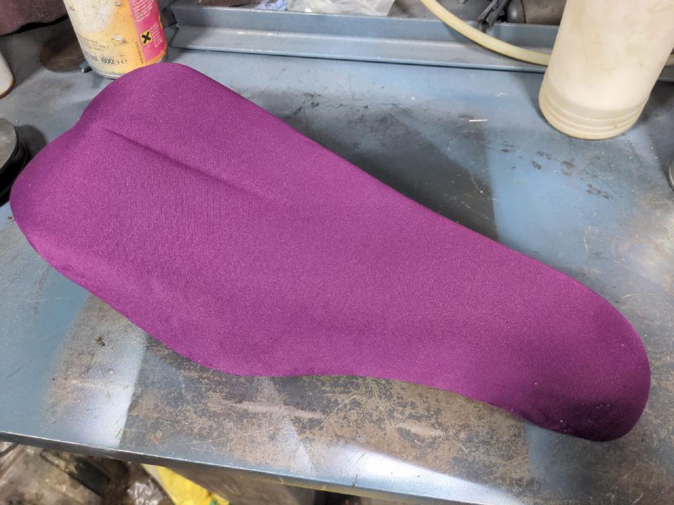 A purple neoprene cover has been stretched over the seat.
