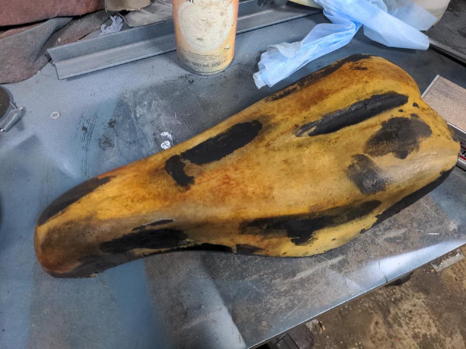 The seat stripped back to the yellow foam. Areas of black indicate where I have applied filler to fill in the losses.