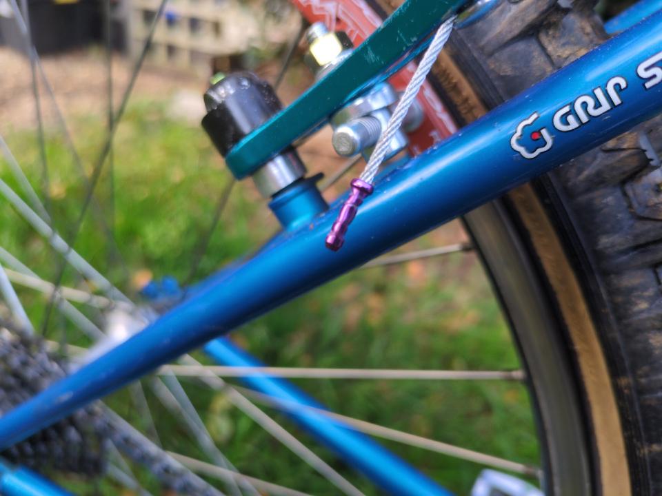 A ferrule - a small piece of metal crimped on to the exposed end of a bicycle brake or gear cable to stop it from fraying. This one is purple.