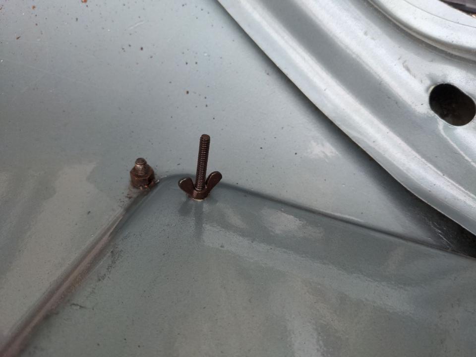 Two screws with wing nuts protruding about two inches into the boot of my car.