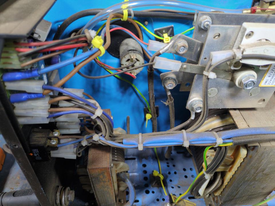 The side panel of my welder removed, showing the electrical internals and a lot of wires.