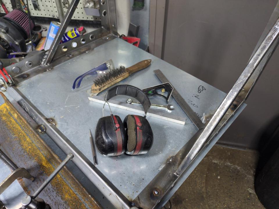 A view of my welding table, with a 700x700mm sheet of galvanised steel clamped to it, with the brackets welded on.