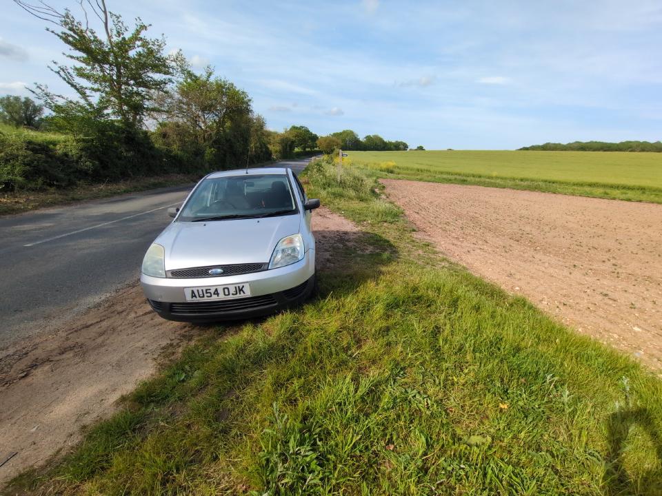 My silver 2004 Fiesta, pulled over in a dirt layby on a quiet rural road.