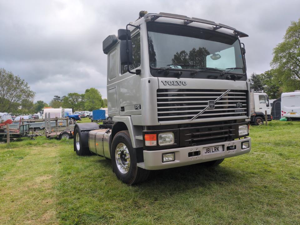 A Volvo F10 in silver. It is a large truck from the early 1990s.